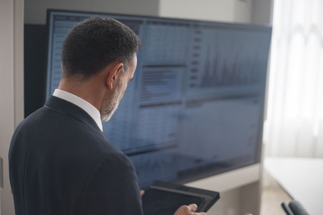 Power BI vs Tableau vs Qlik - Manager vor Monitoren mit Daten